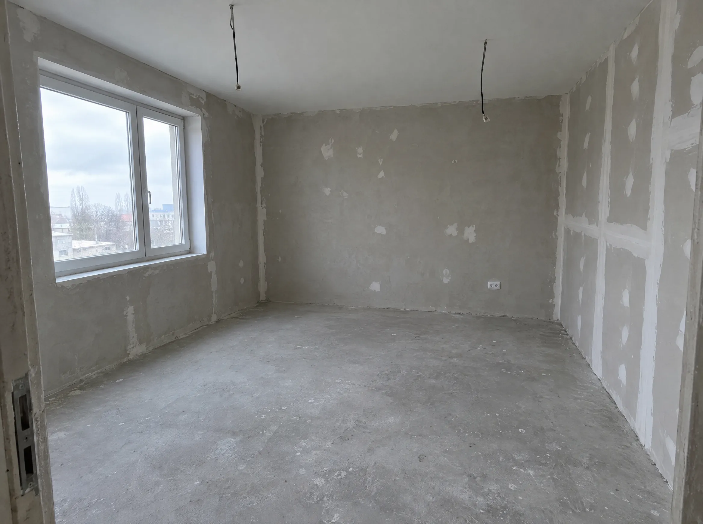 An unfinished bedroom at plaster stage, photographed on a phone