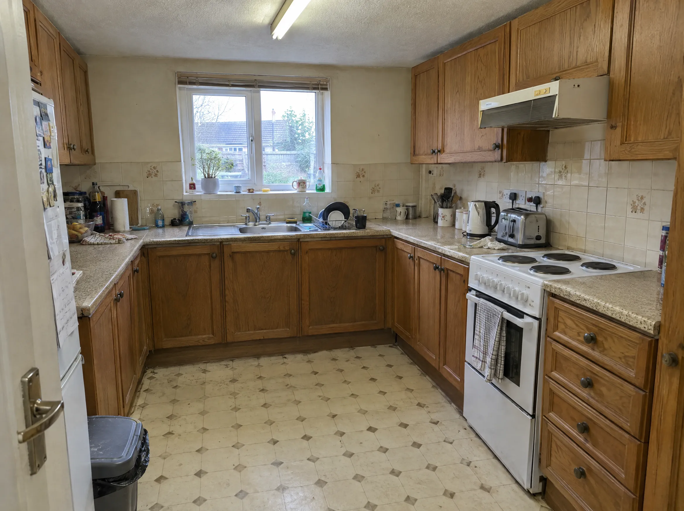 A dated kitchen with oak units, photographed on a phone